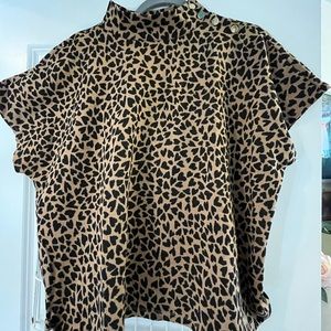 Knit top with short sleeves. Heart print in tan and black.